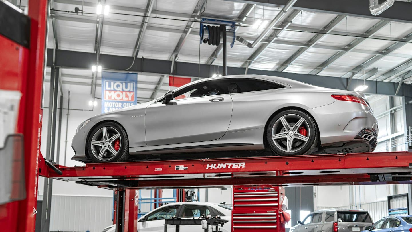 Cupé deportivo de lujo elevado para servicio en un taller de reparación de automóviles.