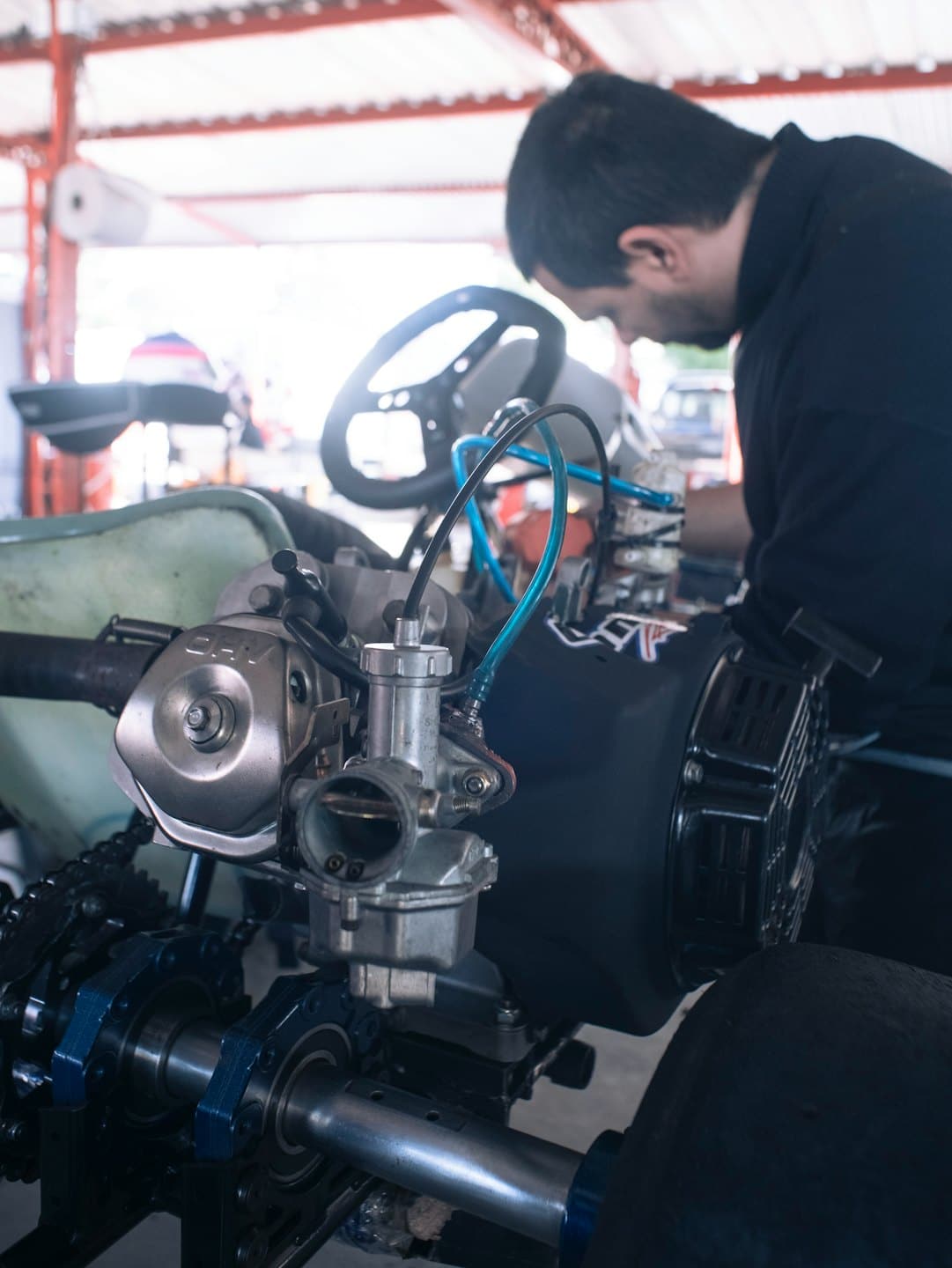 Mecánico trabajando en el motor de un go-kart en un taller.